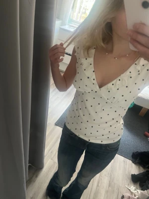 Vit prickig omlottopp med volang - Säljer den söta virala tröjan med svarta prickar. Den är helt ny med prislappen kvar. Säljer eftersom jag råka köpa fel storlek💗💗
