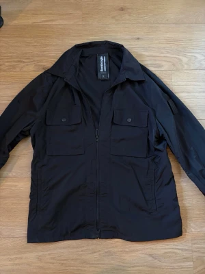 Bomboogie overshirt - Svart overshirt från Bomboogi med två fickor framtill. Den är tunn och passar med allting. Nypris 2700kr och skicket är 10/10. Skriv vid frågor!
