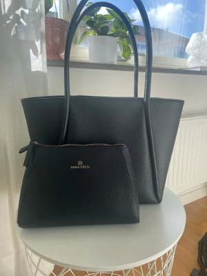 Svart handväska från Anna Field - Stilren svart handväska från Anna Field i konstläder med matchande mindre clutch. Säljer då jag köpt en ny🩷