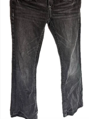 Grå jeans från Gina Tricot - Snygga grå jeans från Gina Tricot med vita kontrastsömmar och dubbla knappar i midjan. Jeansen har en klassisk femficksmodell och är i modell bootcut. Materialet är mjukt denim som ger en avslappnad look. Har använt den två gånger. Priset kan såklart diskuteras🤍