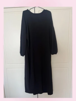 (Abaya) Svart långärmad långklänning - 💓En enkel och stilren (abaya) svart långklänning med rund halsringning och långa ärmar med resår vid ärmsluten. Klänningen har en rak passform och är perfekt för dig som gillar minimalistisk stil. Materialet känns mjukt och bekvämt. Lite nopprig visa ställen ! 💕Har fler abayas om du kollar in i min profil