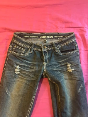 Low waist jeans från Dollhouse - Säljer dessa snygga mörkblå jeans med slitningar fram och markerade sömmar. Låg midja och stretchigt material som sitter snyggt på kroppen💕 ✨Knappt använda ✨Fina detaljer ✨Passform: S   💌Öppen för bud, skriv gärna så löser vi ett bra pris!