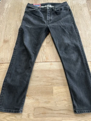 Acne studios jeans | Blå konst | svarta - Säljer ett par svarta jeans från Acne Studios med rak passform och klassisk femficksdesign. Jeansen har normal midja och är tillverkade i slitstark denim. Perfekta för en avslappnad och stilren look.