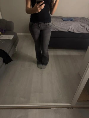 Grå bootcut jeans med låg midja - Säljer ett par grå bootcut jeans med låg midja och klassiska fem fickor. Jeansen har en snygg tvättad look och är i stretchigt denimtyg som sitter tajt över låren och släpper ut vid vaden. De från Gina Young, jag är 160 cm och de passar perfekt i längden. De är använda ett fåtal gånger. De är i storlek 164 men har själv storlek 34-36 på jeans och de passar perfekt i midjan.