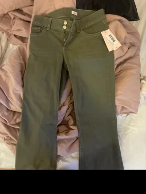 Oanvända Gröna bootcut jeans från Nelly - Aldrig använda då som ej passade som jag hade önskat, pris kan diskuteras men nypris är 699kr
