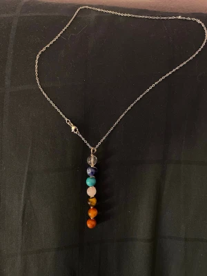 Halsband med kristaller  - Snyggt halsband med tunn silverfärgad kedja och hängsmycke bestående av 7 olika äkta kristaller: klar, blå, turkos, vit, gulbrun och orange. Perfekt för dig som gillar färg och unika accessoarer. Köppt i en lokal kristall shop.