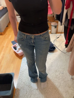 Blå bootcut  jeans med låg midja - Säljer ett par klassiska blå bootcut jeans med låg midja. Jeansen har fem fickor och ljus tvätt. Perfekta till vardags och passar till det mesta. Materialet är mjuk denim i bomull.