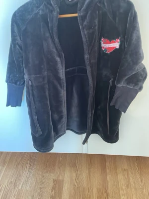 Mjuk svart morgonrock med hjärtdetalj - Säljer en fluffig svart morgonrock för barn