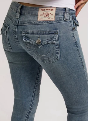 Blå bootcut jeans från True Religion - Snygga blå bootcut jeans från True Religion med klassiska fickor bak och dekorativa sömmar. Jeansen har låg midja, knappgylf och är tillverkade i mjukt denimtyg med lätt stretch för skön passform. Perfekta för en avslappnad och trendig look.