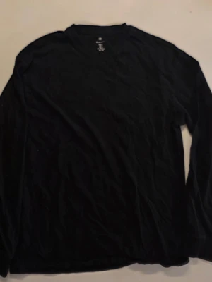 Svart långärmad t-shirt från H&M - En basic svart långärmad t-shirt från H&M med relaxed fit. Tillverkad i mjuk bomull och har en klassisk rund halsringning. Perfekt att styla lager på lager eller bära som den är                                             Mått:      Armlängd: 52 cm    Bröstmått: 49 cm       Hela  67 cm        Storlek: S passar även M