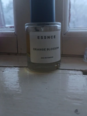 ESSNCE orange blossom parfym - Säljer nu min ESSNCE parfym i doften "orange blossom". Älskar doften men använder den inte så mycket mer. Den är lite använd. Ställ gärna frågor om man har några!❤️ (Den har bleknat lite eftersom den har stått på min fönsterbräda och då har solen blekt den och gjort den lite ljusare än vad den ska vara, men doften har verkligen inte förändrats💕!)