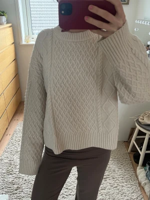 Jättefin kabelstickad tröja - Säljer en krämvit kabelstickad tröja, använd fåtal gånger. Tröjan har ett snyggt flätmönster framtill och ribbade muddar vid ärmslut och nederkant. Skriv ifall fler frågor!🩷🩷🩷