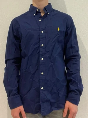 Marinblå skjorta från Ralph Lauren - Ralph Lauren skjorta || Storlek M (slim fit) || Skjortan är i bra skick || Modellen på bilden är 170cm och väger 62kg || Tveka inte på att höra av dig vid frågor eller funderingar 