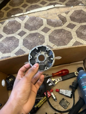 Metallvariator till moped eller scooter - Säljer en rund metallvariator till moped eller scooter. Den är silverfärgad med svarta inslag och har flera fack för vikter. Perfekt för dig som gillar att meka med fordon eller behöver reservdelar till din moppe.