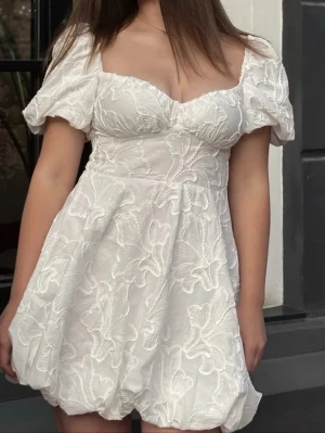 Vit kort klänning med puffärm - Superfin vit klänning  i storlek XS. Klänningen är endast använd en gång och är i nyskick utan några tecken på slitage. Passar perfekt till studenten, midsommar eller andra somriga tillfällen 🤍