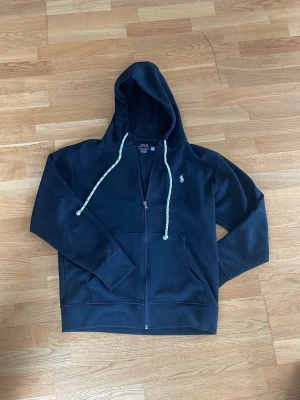 Svart Ralph lauren hoodie - En riktigt snygg Ralph lauren hoodie i storlek M men jag skulle säga att den också kan passa S den är lite liten i storleken. Riktigt snygg svart färgsol passar alla