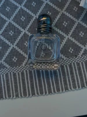 Emporio Armani Stronger With You flaska  - Emporio Armani Stronger With You är en elegant parfym i en genomskinlig glasflaska med rundad kork i metall-look. Flaskan har en stilren och modern design med svart text på framsidan. Perfekt för dig som gillar exklusiva dofter och snygg förpackning.