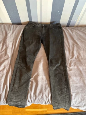 Mörkgrå 502 jeans från Levi's - Säljer ett par mörkgrå straight fit jeans från Levi's i storlek 32-34 med klassisk femficksdesign och dragkedjegylf. Jeansen har en diskret tvättad look och är tillverkade i slitstark denim. Passar perfekt till en avslappnad stil. Priset går att diskutera!