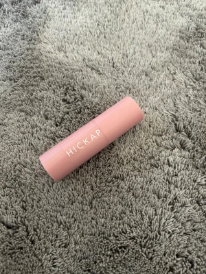 Hickap Wonder Stick Blush Rosewood Pink - Hickap Wonder Stick Blush & Lips i färgen Rosewood Pink är en krämrouge i stickformat. Den har en mjuk rosa nyans och kommer i en stilren, ljusrosa plastförpackning. Perfekt för att ge kinderna och läpparna en naturlig glow. Endast testad!! 
