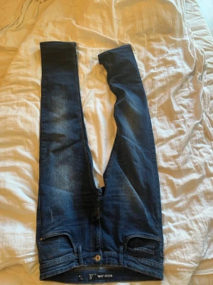 Mörkblåa jeans - Inget jätte stort märke men snygga jeans för väldigt bra pris. Storlek finns på bild. Slitningar som är trendiga och snygga