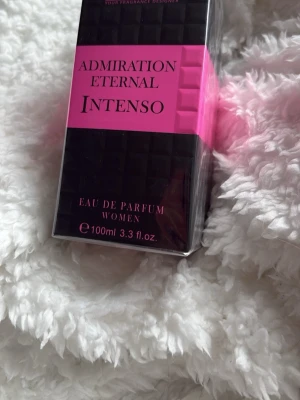 Admiration Eternal Intenso parfym - Säljer en Eau de Parfum för kvinnor, Admiration Eternal Intenso. Flaskan är 100 ml och kommer i en snygg svart och rosa förpackning med modern design. Perfekt för dig som vill ha en intensiv och elegant doft.