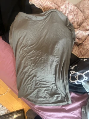 Olivgrön basic shirt i bomull - En enkel olivgrön shirt i mjukt bomullsmaterial. Klassisk passform med korta ärmar och rund halsringning. Perfekt att matcha med jeans eller shorts för en clean och avslappnad stil.