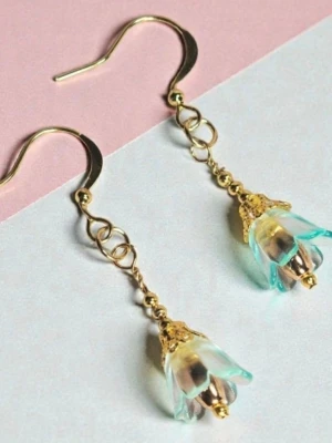 Blomformade örhängen i guld och turkos - Unika örhängen med blomformade hängen i transparent turkos och guld. Krokarna är guldpläterade och detaljer är i guldfärgad metall och blomman är gjord av akryl med dekoration inuti. Perfekta för dig som vill ha något lekfullt och färgglatt.