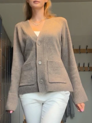 Beige kofta med stora fickor - Mysig beige kofta med v-ringning och tre stora knappar framtill. Är i M men passar S. 