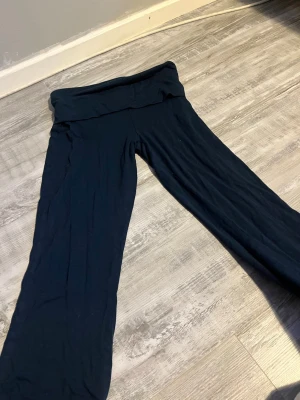 Mörkblå yoga byxor från 157 - Mörkblå yoga byxor från 157 med bred linning och raka ben. Tillverkade i mjukt och stretchigt material som sitter skönt på kroppen. Perfekta för en avslappnad och bekväm stil.