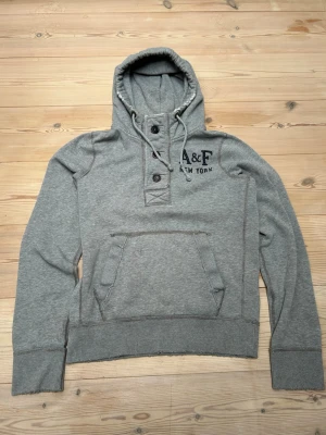 Abercrombie & Fitch hoodie  - Säljer denna eftertraktade Abercrombie & Fitch hoodie med knappar, den är i fint skick! Den är i M men passar också S.  Hör av er vid minsta lilla fråga! Pris ej hugget i sten!  Kolla min profil för mer liknande plagg 😊