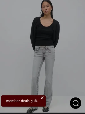 Grå bootcut jeans stl 32 - Säljer ett par ljusgrå bootcut jeans med tydliga kontrastsömmar och klassisk femficksdesign. Jeansen har normal midja och raka ben som går ut lite nedtill. Perfekta för en avslappnad och trendig look. Stl 32