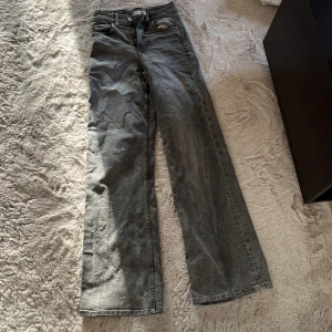 Gråa wide jeans från Perfect Jeans - Säljer ett par gråa jeans från Perfect Jeans med breda ben och klassisk femficksdesign. Jeansen har hög midja, raka sömmar och snyggt tvättad finish. Perfekta för dig som gillar en avslappnad och trendig look.