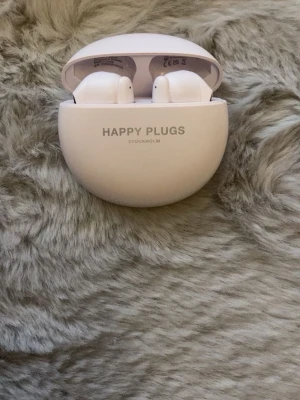 Happy Plugs vita trådlösa in-ear - Snygga vita trådlösa in-ear hörlurar från Happy Plugs med matchande laddningsetui. Smidig och stilren design som är enkel att ta med sig. Perfekta för musik, poddar eller samtal på språng. Laddningsetuiet är rundat och kompakt.