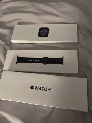 Apple Watch med svart sportband - Apple Watch SE (gen2) 40 mm midnight i originalkartong med laddare och armband. Helt ny och försäkrad i ca 10 månader. Org pris 3300kr