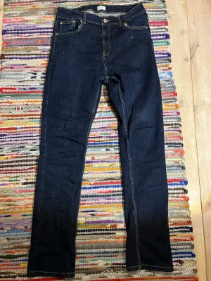 Mörkblå slim jeans med kontrastsömmar - Sjukt feta mörkblå slim jeans från Grunt i storlek W31 och L33 med klassiska kontrastsömmar och femficksmodell. Jeansen har normal midja och raka ben, perfekta till en avslappnad stil. Materialet är stretchigt denim för extra komfort.