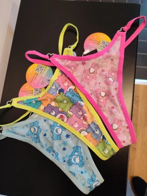 Thong set - ROMWE X CAREBEARS set med stringtrosor. 3st i blått, rosa och limegrönt. Alla är nya med prislappar kvar. Storlek S på alla. Dessa själjes som ett set!  Välkommen att fynda!