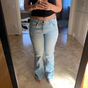 Ljusblå raka jeans med slitningar - Utsvängda jeans med slits och fina fickor . de är nedklippta en bit men är fortfarande långa på mig som är 158 cm