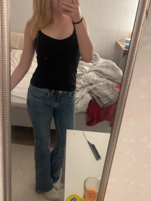 Blå bootcut jeans från Gina Tricot  - Säljer ett par klassiska blå bootcut jeans med hög midja och raka ben från Gina. Jeansen har en tidlös tvätt och femficksmodell. Perfekta för dig som gillar en avslappnad men ändå trendig look. Säljer då de inte passar mig så bra eftersom byxorna är köpta från vuxenavdelningen istället för Gina Young. Byxorna är i storlek 34 och har ett mjukt och stretchigt material. Nästan aldrig använda (Ordinarie pris: 499,95 kr)