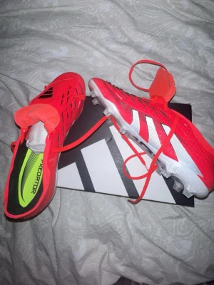 Adidas Predator röda fotbollsskor - Tvär snygga adidas predators röda med tunga,  ANVÄNDA ENDAST 1 GÅNG lättare sagt sjuuuukt bra skick, köpte dessa för 1400kr säljs för endast 800.     Riktigt fräscha och snygga skor enligt mig.