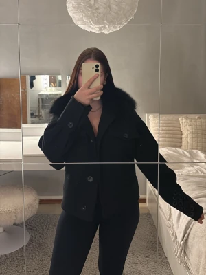 Svart meotine kappa med päls.  - Den kända meotine jackan, säljer denna pågrund av att den ej kommit till användning. Använd högst 4 gånger. Så den är i fint skick. Ny pris 3000, säljs för 1500