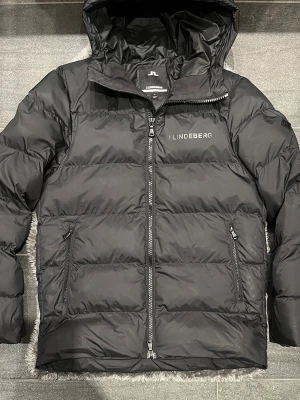 J.Lindeberg Vinterjacka Svart S/M - men passar även M. Mycket fint skick och sparsamt använd. Stilren och varm jacka som funkar perfekt under höst och vinter