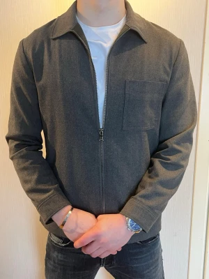 Mörkgrå J. Lindeberg overshirt med dragkedja - Stilren mörkgrå overshirt med rak passform.