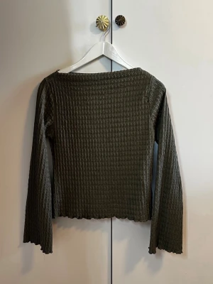 Mörkgrön ribbad topp från 157 - Säljer en grön långärmad topp från 157 i räfflad struktur med utsvängda ärmar. Står att det är XS men funkar som XS,S & M.                Hör av dig vid frågor!☺️