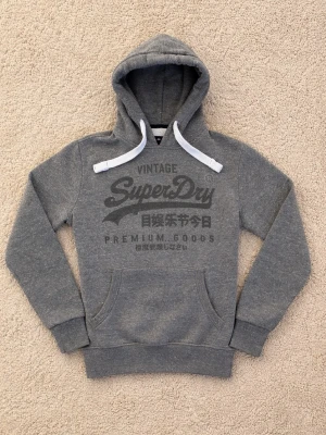 Superdry Hoodie - Snygg grå hoodie från Superdry. - Eftertraktad Colourway ganska svår att få tag på. - Storlek: M men sitter närmare S enligt mig. - Pris: 599kr - Först till Kvarn!