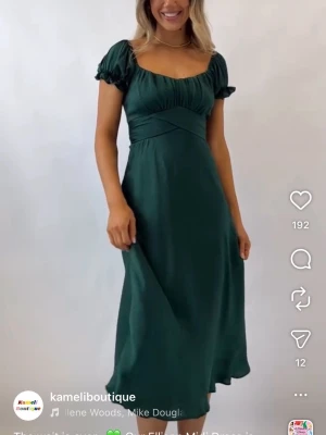 Mörkgrön omlottklänning med rosett - Supersöt mörkgrön klänning med omlottdetalj och rosett i ryggen. Klänningen har korta puffärmar och en smickrande v-ringning. Perfekt för dig som vill ha en feminin och trendig look. Säljer då den är för liten för mig. Aldrig använd, nyskick. OBS lånade bilder då den inte passar mig. Kontakta mig vid frågor. 