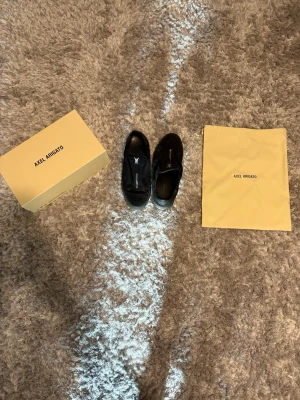 Axel Arigato clean 90 zip - Snygga svarta sneakers från Axel Arigato i mocka med cool dragkedja framtill istället för klassiska snören. Minimalistisk design och diskret logga på sidan. Kommer med originalkartong och dustbag.