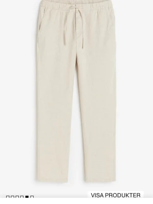 Beiga linnebyxor med dragsko - Snygga och luftiga linnebyxor i beige med rak passform och elastisk midja med dragsko. Byxorna har sidofickor och diskret bakficka. Perfekta för en chill och avslappnad stil under varma dagar.