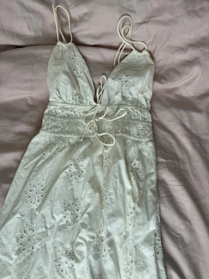 Vit somrig klänning med broderi - Söt vit klänning med tunna axelband och broderade blommor. Klänningen är i storlek s men passar  xs till m då banden är justerbara och beror väl på hur lång man vill ha den! Köpt på Ginatricot för 899kr! 🌸💞