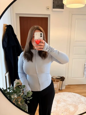 Ljusblå yoga jacka med dragkedja - Snygg ljusblå yoga jacka med dragkedja framtill och hög krage. Jackan är figurnära och har långa ärmar. Prislapp kvar