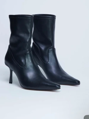 Svarta spetsiga stövletter i skinn - Säljer ett par svarta stövletter med spetsig tå och smal klack. Tillverkade i slätt skinn med en stilren, minimalistisk design. Klackhöjden är medelhög och skaften är något högre än ankeln.